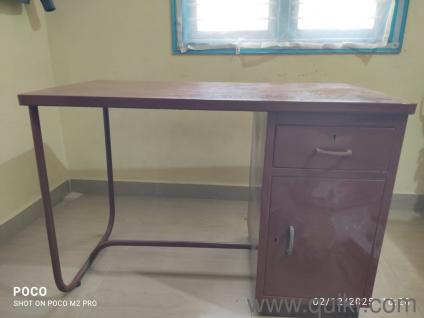Office/Study table made of steel frame and freshly painted with brown paint.Well equipped with storage unit and a new plastic white chair.