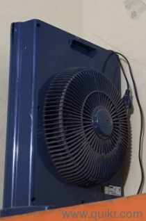 "It features a dark blue plastic outer casing with a circular safety grille, commonly used for personal or tabletop cooling."