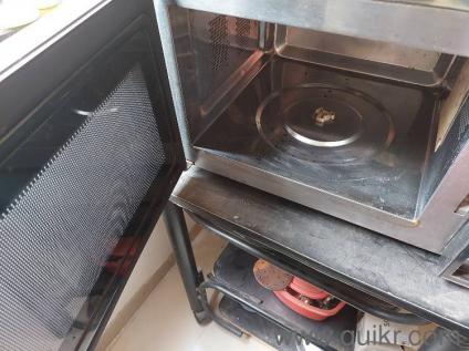 Convection Microwave in good condition for sale along with the table below it