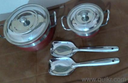 Two stainless steel cooking and serving bowls, with ladles